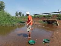 Mr. Louis gold panning soil samples in Uganda